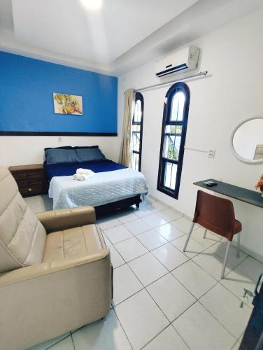 a bedroom with a bed and a couch and a table at Ponta Negra Suites & Apart in Natal