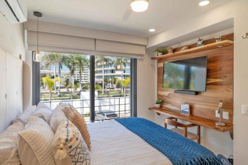 a bedroom with a large bed and a flat screen tv at Vista Natura in Nuevo Vallarta