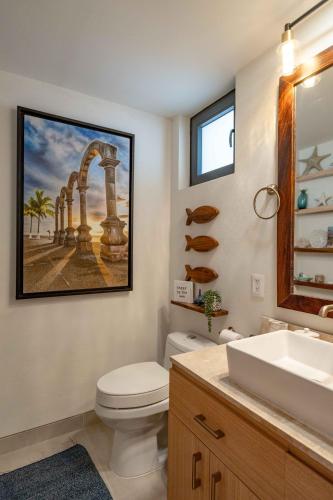 a bathroom with a white toilet and a sink at Vista Natura in Nuevo Vallarta