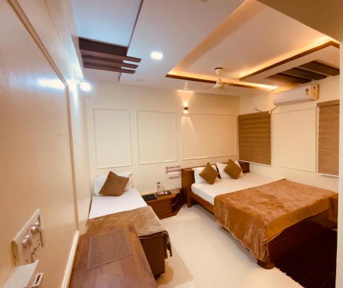 a bedroom with two beds and a ceiling at AL-MANAL 306 Premium Room Triple Bed in Bhatkal