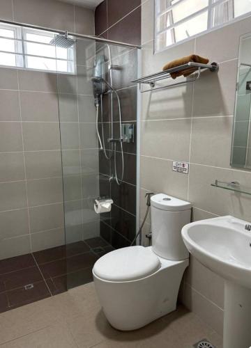 a bathroom with a shower and a toilet and a sink at 722 Homestay in Kuching