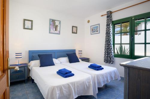a bedroom with two beds with blue towels on them at Casa Steve in Playa Blanca