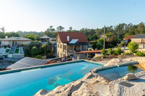 a large swimming pool with a house in the background at Casa Pinto Oliveira in Bodiosa
