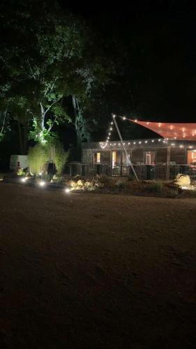 a house lit up at night with lights on it at Camping Du Perche Bellemois in Bellême