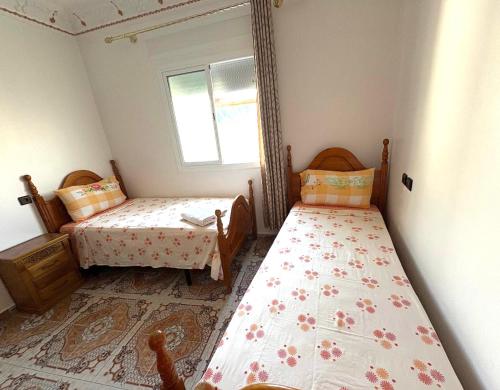 a bedroom with two beds and a window at Beach House in Asilah