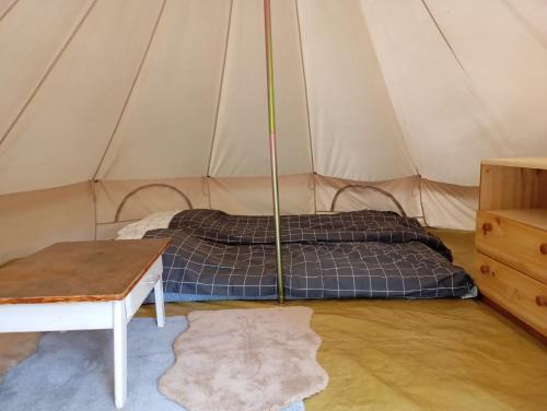 a tent with two beds and a table in it at La Ramie in Marat