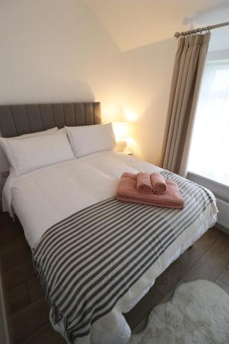 a bed with a towel on it with a window at No 26 Town House in Killarney