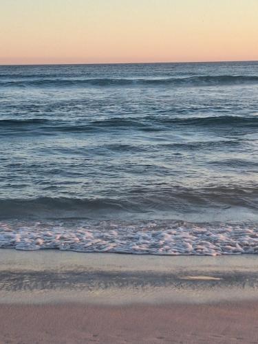 a view of the ocean from the beach at sunset at Quartos da lagoa in Cabo Frio