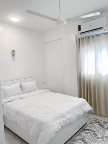una camera da letto bianca con un letto bianco e una finestra di Star guest house a Luxor