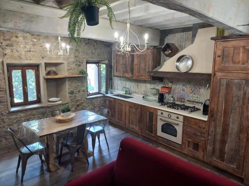 Una cocina con gabinetes de madera y una mesa con sillas. en Il nido di Matilde, en Rossena
