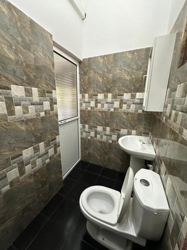a bathroom with a toilet and a sink at Sun & Moon Hostel in Mirissa