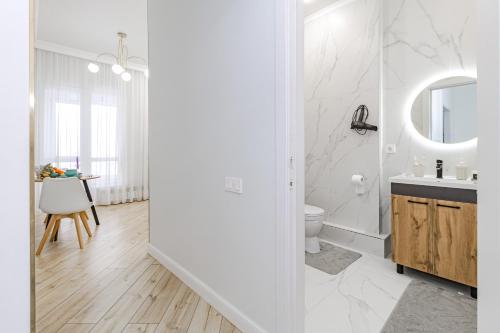 a white bathroom with a sink and a toilet at Medina Central Loft- 118 in Astana