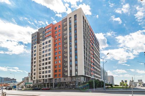 a tall building on a city street with a cloudy sky at Medina Central Loft- 118 in Astana