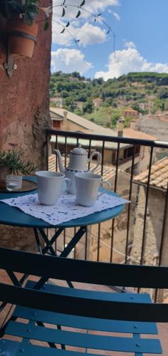 a table with two tea cups on a balcony at CasaFraBorgo in Sacrofano