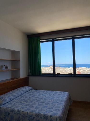 una camera con un letto e due grandi finestre di Sul Tetto di Gallipoli a Gallipoli