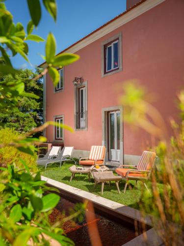 a house with a patio with chairs and a table at Rosegarden Essence Sintra AL - by Unlock Hotels in Sintra