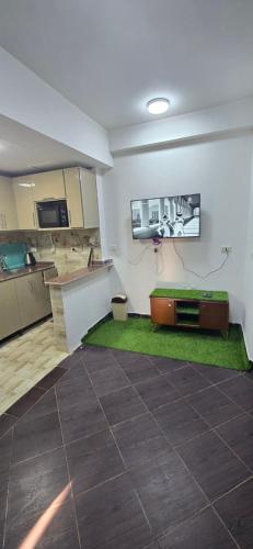 Una sala de estar con cocina con alfombra verde. en PORTO MATROUH chalet families only, en Marsa Matruh