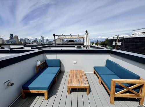 Una terraza en la azotea con dos bancos azules y una mesa. en 2BR 2BA Capitol Hill Cozy Haven- Rooftop, en Seattle