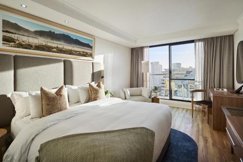 a hotel room with a large bed and a desk at President Hotel in Cape Town
