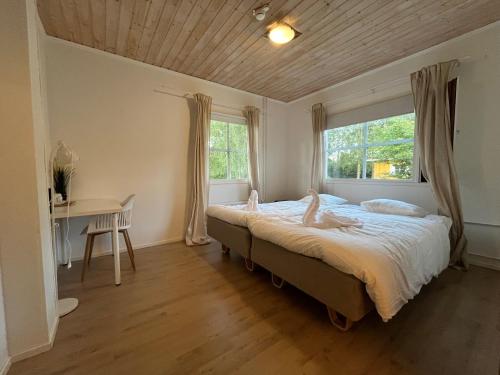 a bedroom with a bed and a desk and a window at Lakeside hotelli ravintola in Rantasalmi