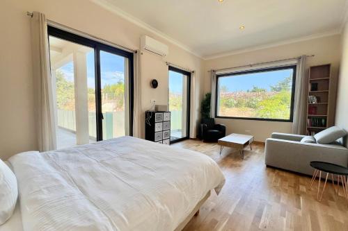Un dormitorio con una gran cama blanca y un sofá. en Villa La Mascotte, en Beaulieu-sur-Mer