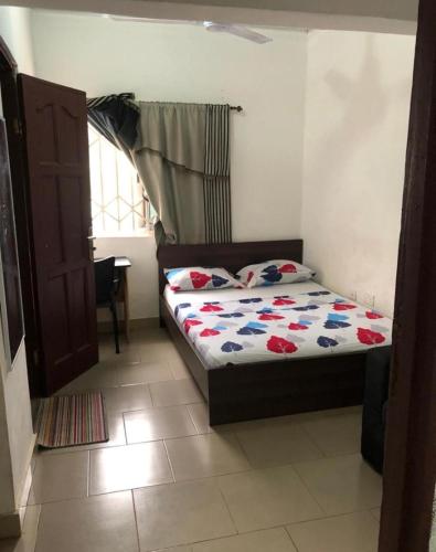 a small bedroom with a bed with flowers on it at MAC-P GUESTHOUSe in Aiyimensa