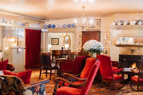 a living room with red chairs and a fireplace at The Red Lion Inn in Stockbridge