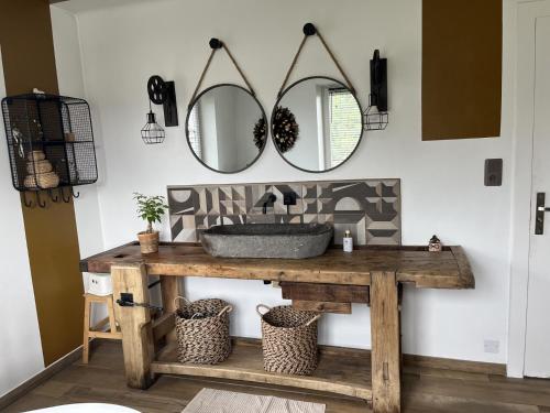 a bathroom with a sink and two mirrors at Villa 170m2 avec piscine , sauna , jacuzzi , terrain de petanque in Nompatelize