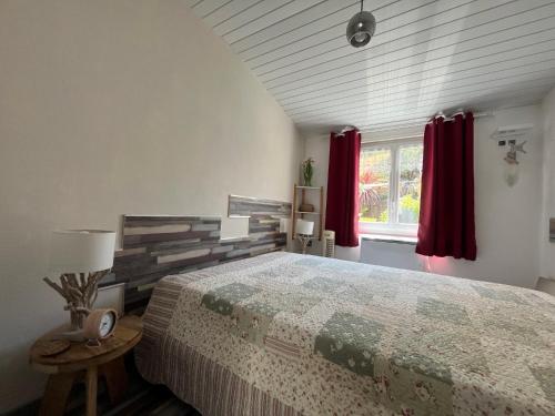 1 dormitorio con 1 cama grande y cortinas rojas en Au Coeur du Fief Naton, en Le Château-dʼOléron