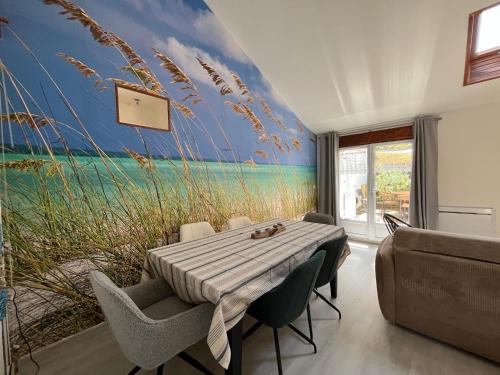Un comedor con un mural de una playa y césped. en Au Coeur du Fief Naton, en Le Château-dʼOléron