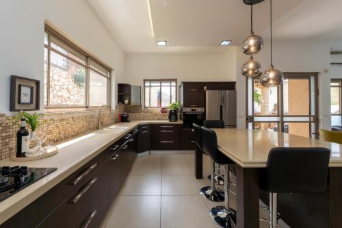 a kitchen with a large island with black cabinets at וילת נופש המלך שלמה in Wadi Keren