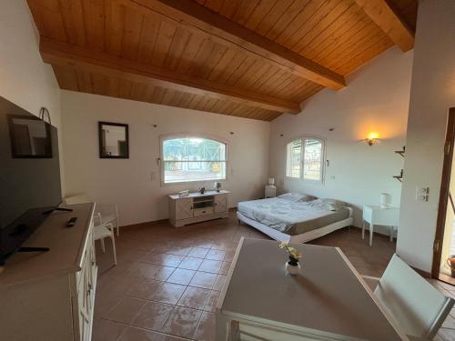 a living room with a bed and a table at La Villa kinza in Les Adrets de l'Esterel