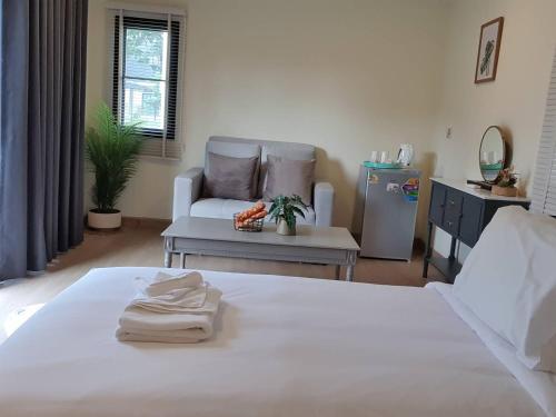 a living room with a white bed and a chair at Nordika Hill in Pak Chong