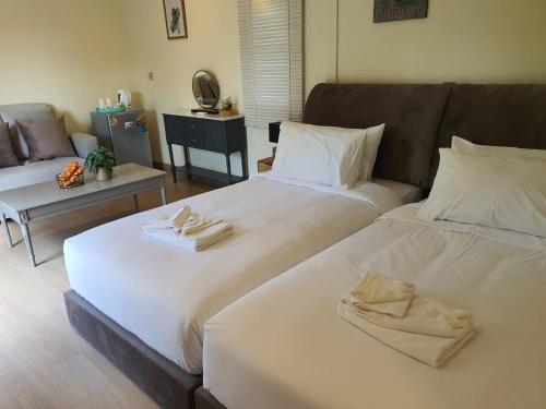 a room with two beds and a couch at Nordika Hill in Pak Chong