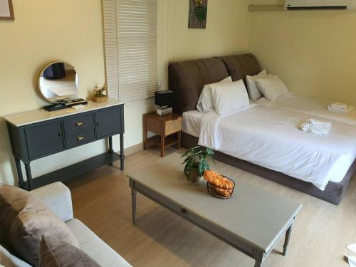 a bedroom with a bed and a table with a mirror at Nordika Hill in Pak Chong