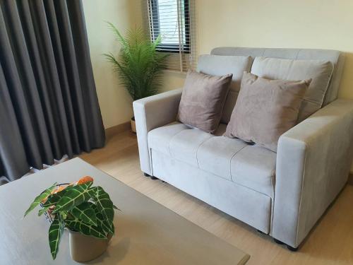 a living room with a couch and a potted plant at Nordika Hill in Pak Chong