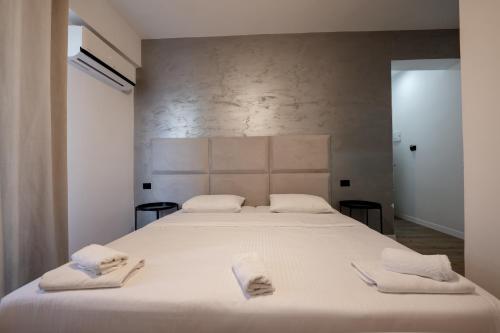 a bedroom with a large white bed with towels on it at Diamond Central Boutique Hotel in Sarandë