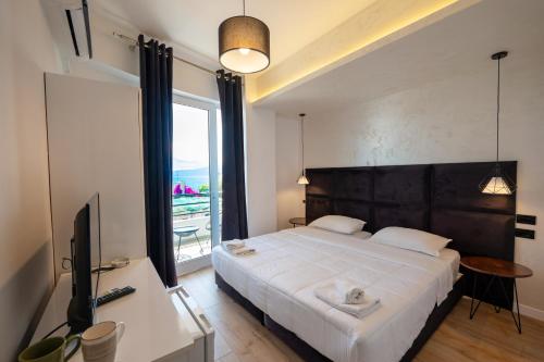 a bedroom with a large white bed and a window at Diamond Central Boutique Hotel in Sarandë