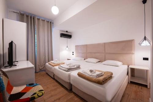 a bedroom with two beds and a television in it at Diamond Central Boutique Hotel in Sarandë