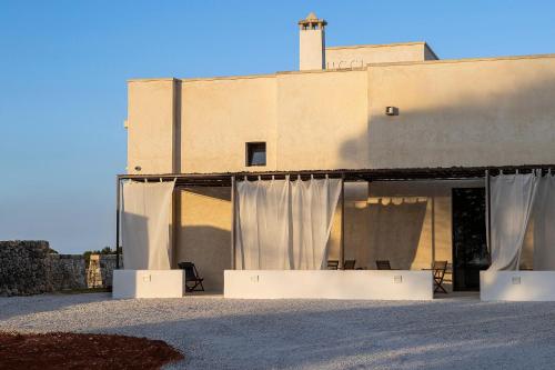 a building with white curtains in front of it at Masseria LOGGIA PUCCI in Torre Chianca