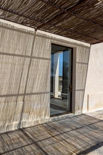 a building with a large glass door in it at Masseria LOGGIA PUCCI in Torre Chianca