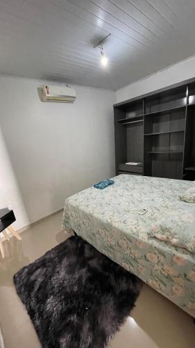 a bedroom with a bed and a rug at Casa Grande com 2 quartos e 3 camas in Juazeiro do Norte