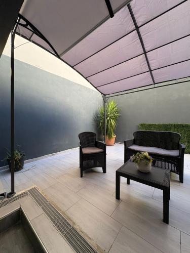 acovered patio with two chairs and a table and a bench at suite Nicolai 165 in Bari