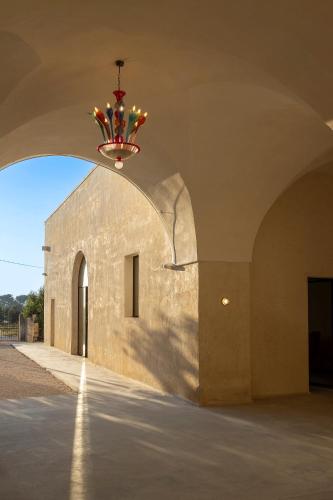 an archway with a chandelier in front of a building at Masseria LOGGIA PUCCI in Torre Chianca