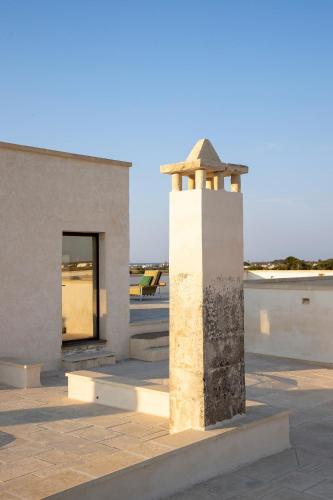 a monument in front of a building at Masseria LOGGIA PUCCI in Torre Chianca