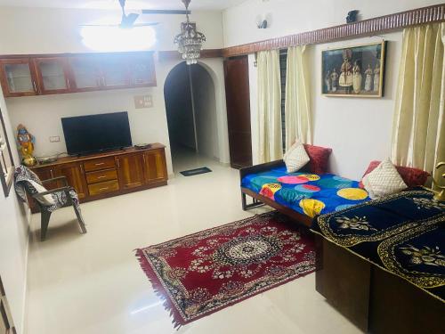 a living room with a couch and a flat screen tv at Homestay - Heaven Aumgarden in Trivandrum