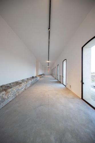 an empty room with a long hallway with windows at Masseria LOGGIA PUCCI in Torre Chianca
