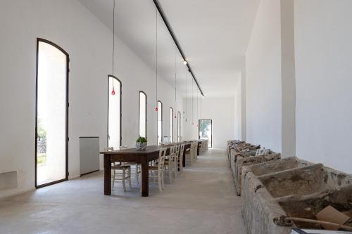 a long dining room with tables and chairs at Masseria LOGGIA PUCCI in Torre Chianca