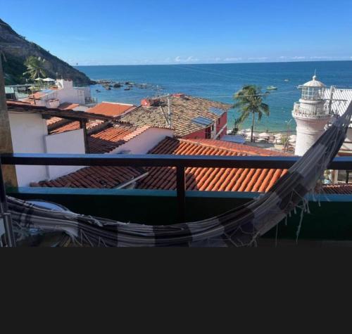 a hammock on top of a building with a lighthouse at Suíte Farol do Morro in Cayru