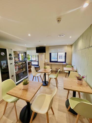 a restaurant with tables and chairs in a room at Hostal LA POETISA - Auto Check-in in Culleredo